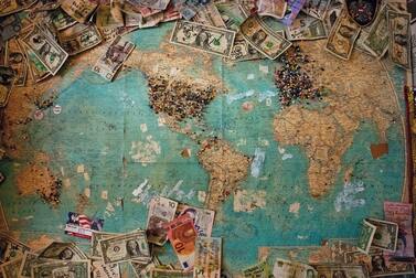 A world map with different money papers representing capitalism.