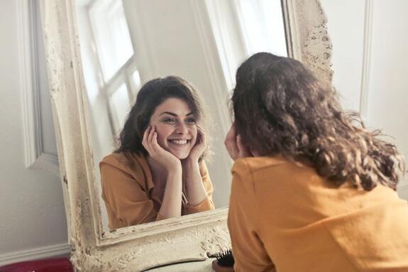 Woman smiling in the mirror. 
