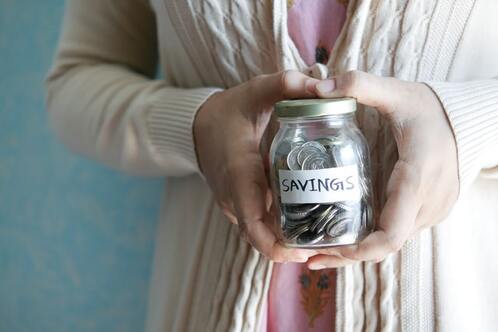 A woman holding a savings jar.